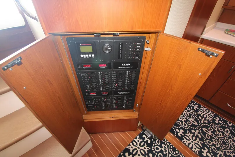 Slide: The Image of Electrical panel inside 2013 Cabo 40 Hardtop Express yacht, with open wooden cabinet doors. - 42