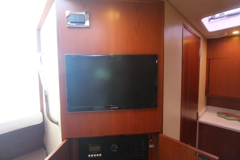 Slide: The Image of Interior of 2013 Cabo 40 Hardtop Express with mounted TV and wooden cabinetry. - 43