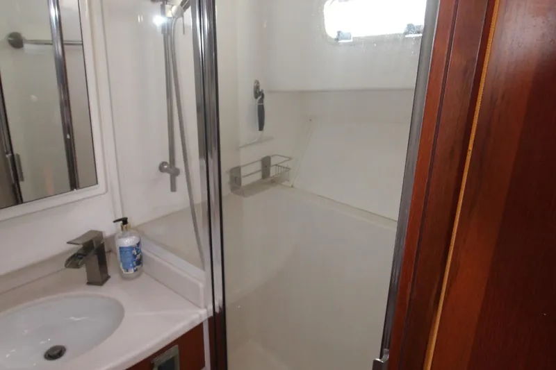 Slide: The Image of 2013 Cabo 40 Hardtop Express bathroom with shower, sink, and wooden accents. - 47