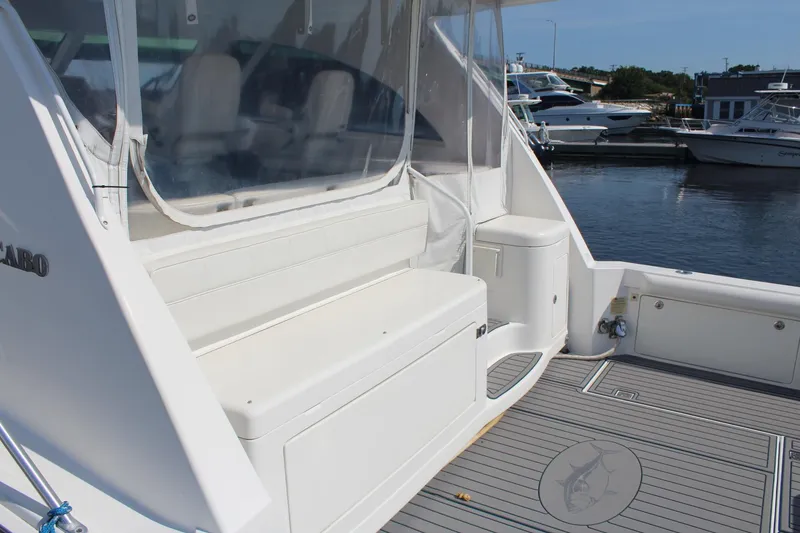 Slide: The Image of 2013 Cabo 40 Hardtop Express yacht with white seating and marina view. - 9