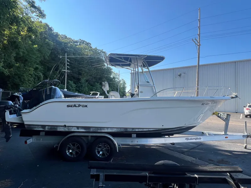 Slide: The Image of 2011 Sea Fox 236CC Pro Series boat on a trailer in a parking lot. - 11