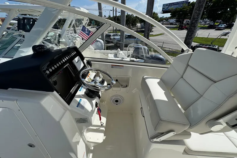 Slide: The Image of 2025 World Cat 296 DC boat interior with steering wheel and seating. - 6