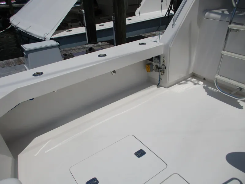 Slide: The Image of Bertram 60 Convertible 2000 yacht deck with clean white finish and storage compartments. - 28