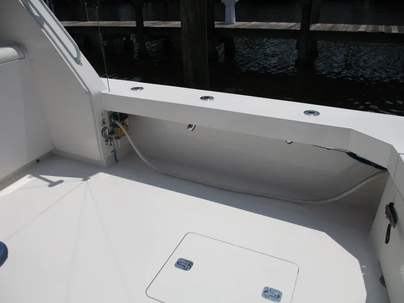 Slide: The Image of Bertram 60 Convertible 2000 yacht deck with storage compartment and fishing rod holders. - 29