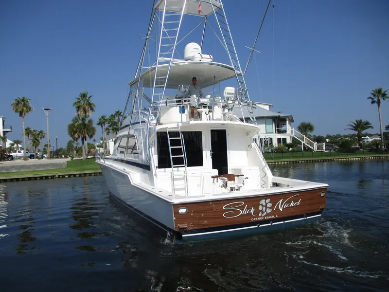 Slide: The Image of Bertram 60 Convertible 2000 yacht on water, rear view with tower and palm trees. - 3