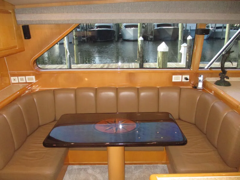 Slide: The Image of Bertram 60 Convertible 2000 yacht interior with leather seating and table, dock view. - 47