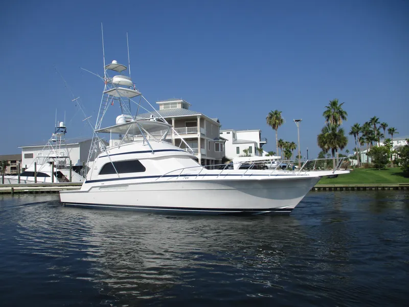 Slide: The Image of 2000 Bertram 60 Convertible yacht docked near waterfront homes. - 7