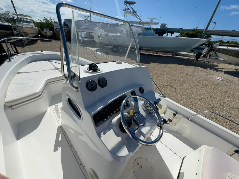 Slide: The Image of 2007 Boston Whaler 220 Dauntless boat console and steering wheel in a marina. - 17