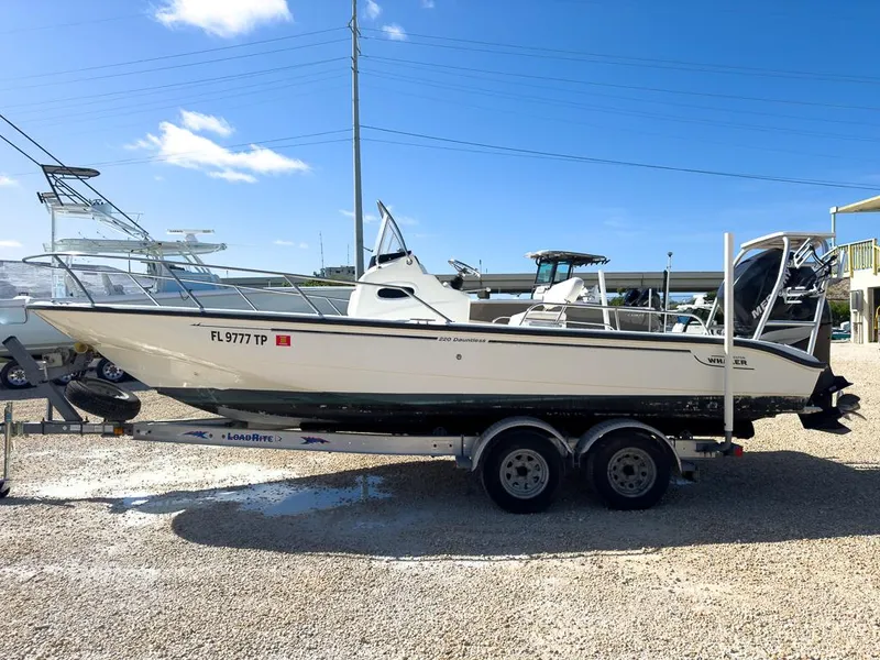 Slide: The Image of 2007 Boston Whaler 220 Dauntless boat on a trailer in a marina. - 6