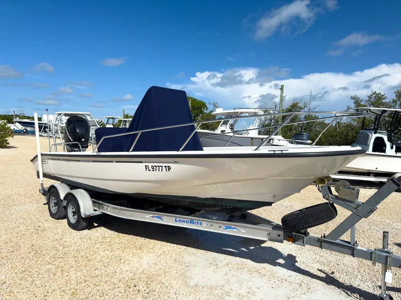 Slide: The Image of 2007 Boston Whaler 220 Dauntless boat on trailer, parked outdoors under clear blue sky. - 8
