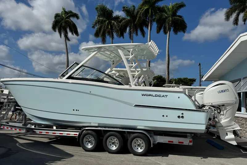 The Image of 2026 World Cat 280 DC-X boat on trailer, palm trees in background, sunny day. - 0