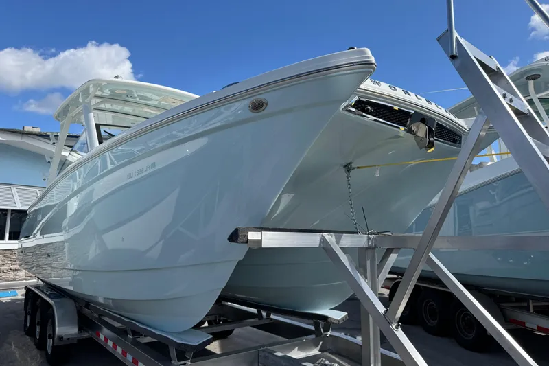 Slide: The Image of 2026 World Cat 280 DC-X boat on trailer under clear blue sky. - 10