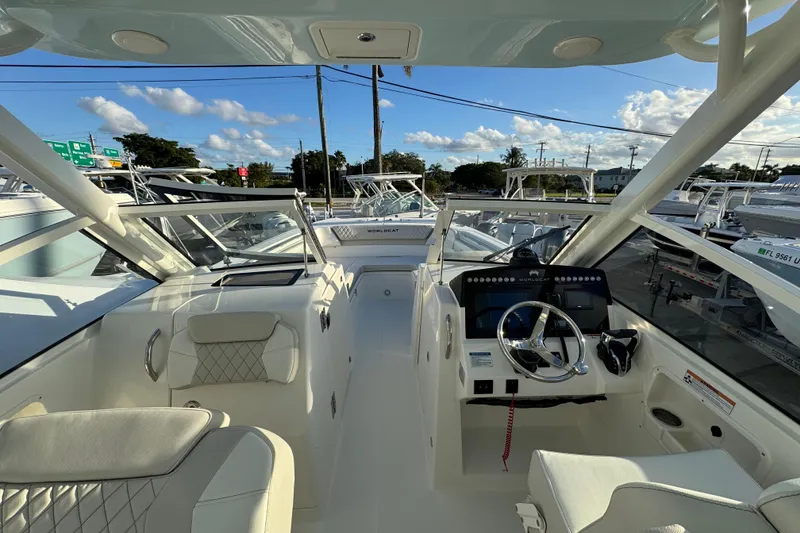 Slide: The Image of 2026 World Cat 280 DC-X boat interior with modern helm and seating under clear skies. - 14