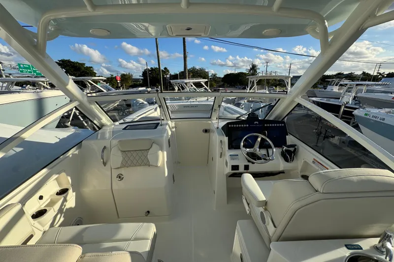 Slide: The Image of 2026 World Cat 280 DC-X boat interior with modern helm and seating under clear skies. - 15