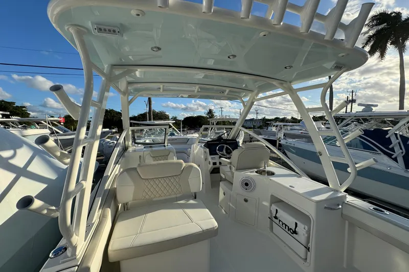 Slide: The Image of 2026 World Cat 280 DC-X boat interior with seating and helm, under a clear blue sky. - 17