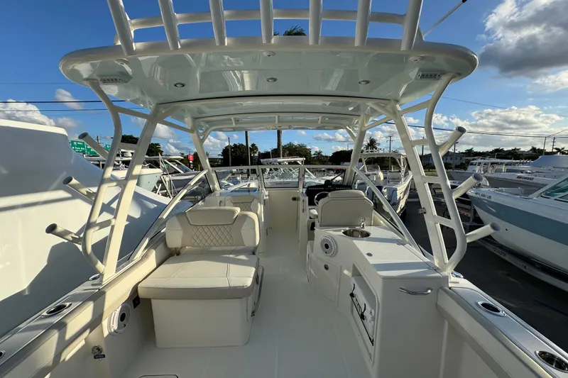 Slide: The Image of 2026 World Cat 280 DC-X boat interior with seating and helm, under a clear blue sky. - 19