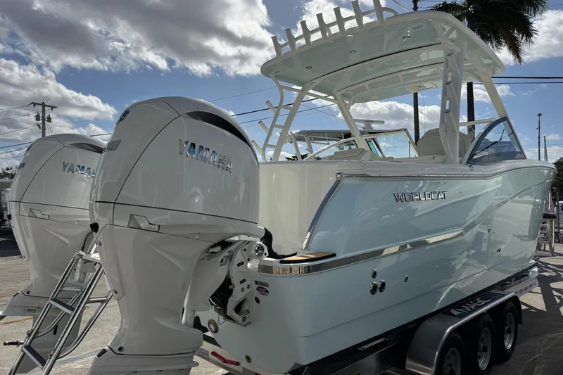 Slide: The Image of 2026 World Cat 280 DC-X boat with twin Yamaha engines, parked under a cloudy sky. - 2