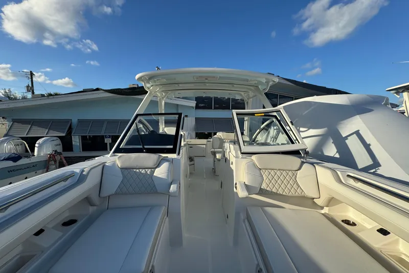 Slide: The Image of 2026 World Cat 280 DC-X boat interior with luxurious seating and open deck under blue sky. - 22