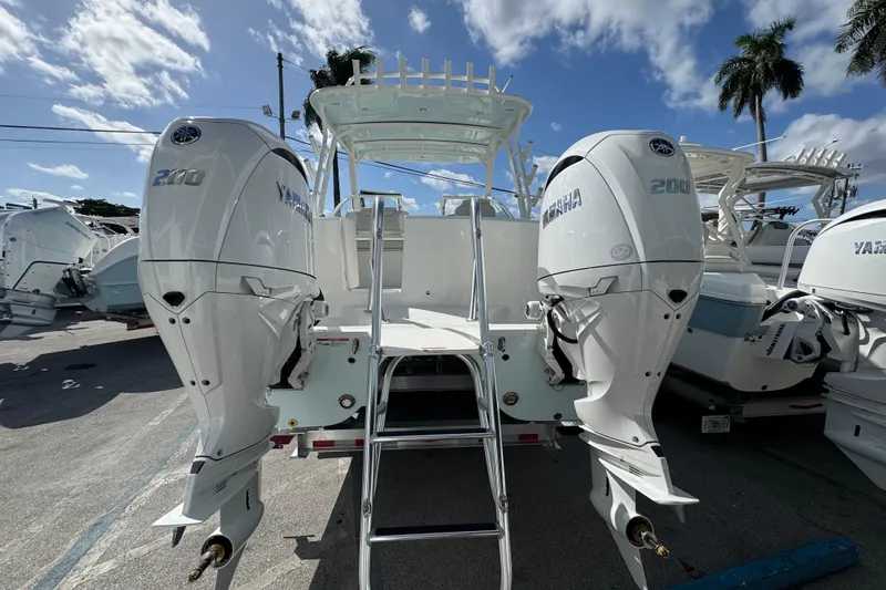 Slide: The Image of 2026 World Cat 280 DC-X boat with dual Yamaha 200 engines, parked under a sunny sky. - 6