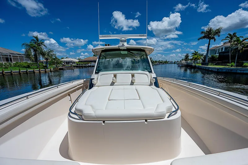 Slide: The Image of 2019 Grady-White Canyon 456 boat on a sunny day with blue skies and palm trees. - 13