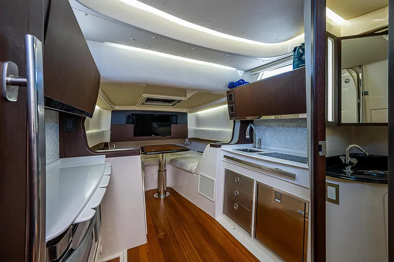 Slide: The Image of 2019 Grady-White Canyon 456 interior cabin with modern amenities and wood flooring. - 14