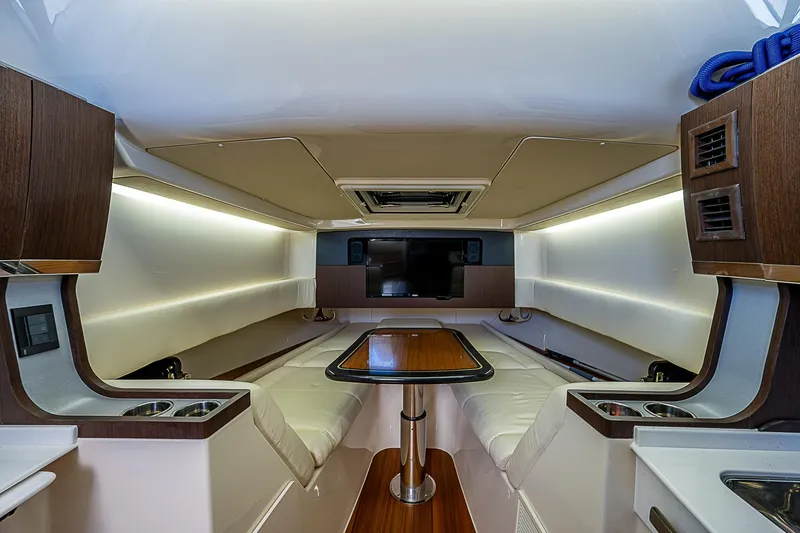 Slide: The Image of 2019 Grady-White Canyon 456 cabin interior with seating, table, and TV. - 16