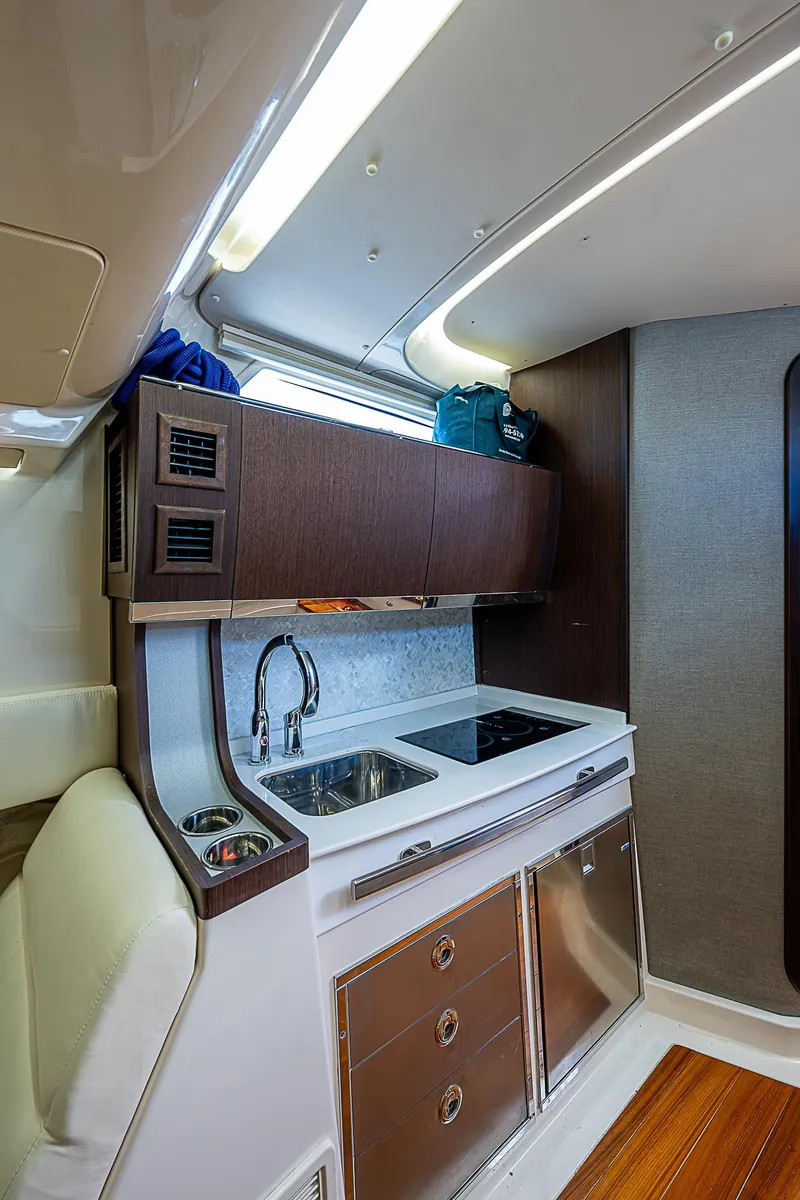 Slide: The Image of 2019 Grady-White Canyon 456 boat interior kitchen with sink and stove. - 18