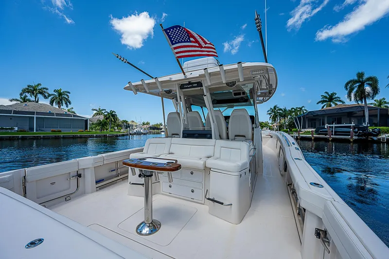 Slide: The Image of 2019 Grady-White Canyon 456 boat with American flag, docked in a tropical marina. - 31