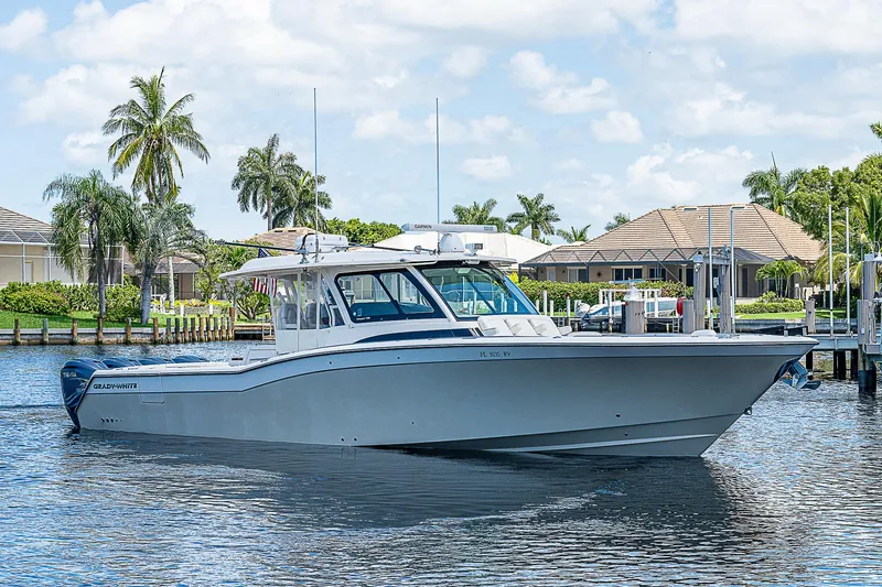 Slide: The Image of 2019 Grady-White Canyon 456 boat cruising on a sunny day near waterfront homes. - 46