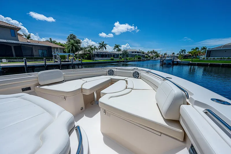 Slide: The Image of 2019 Grady-White Canyon 456 boat with luxurious seating, docked in a scenic waterfront area. - 8