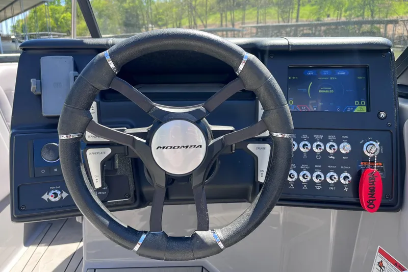 Slide: The Image of 2024 Moomba Max boat dashboard with steering wheel and control panel. - 10