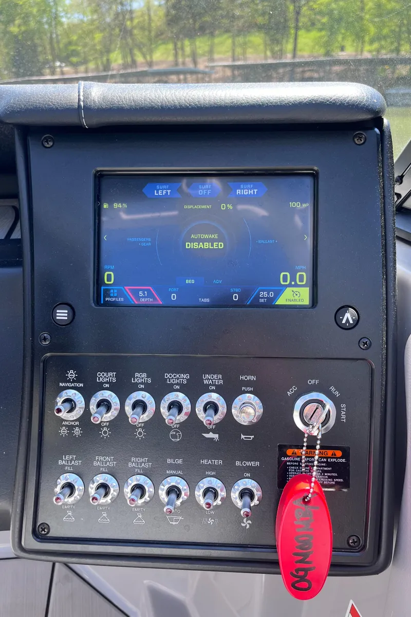 Slide: The Image of 2024 Moomba Max dashboard with touchscreen and control panel, featuring various switches and a red key tag. - 11