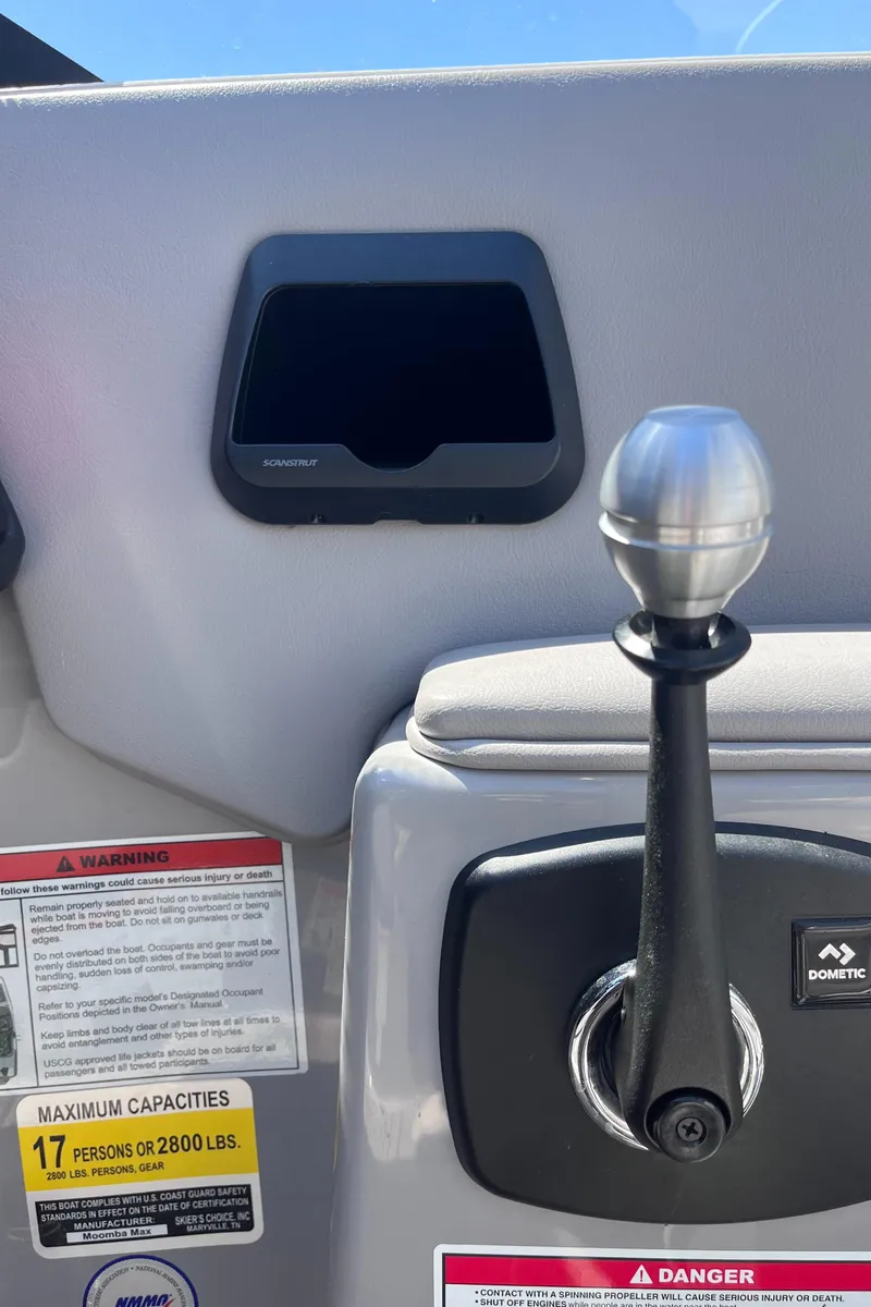 Slide: The Image of 2024 Moomba Max boat dashboard with control lever and warning labels. - 15