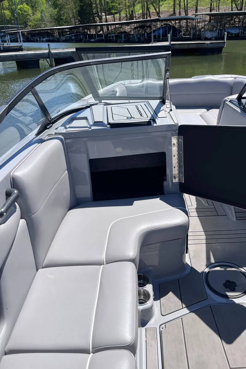 Slide: The Image of 2024 Moomba Max boat interior with gray seating and open storage compartment. - 18
