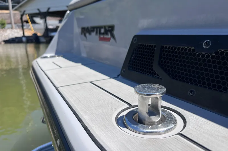 Slide: The Image of 2024 Moomba Max boat with Raptor engine detail, docked on calm water. - 23