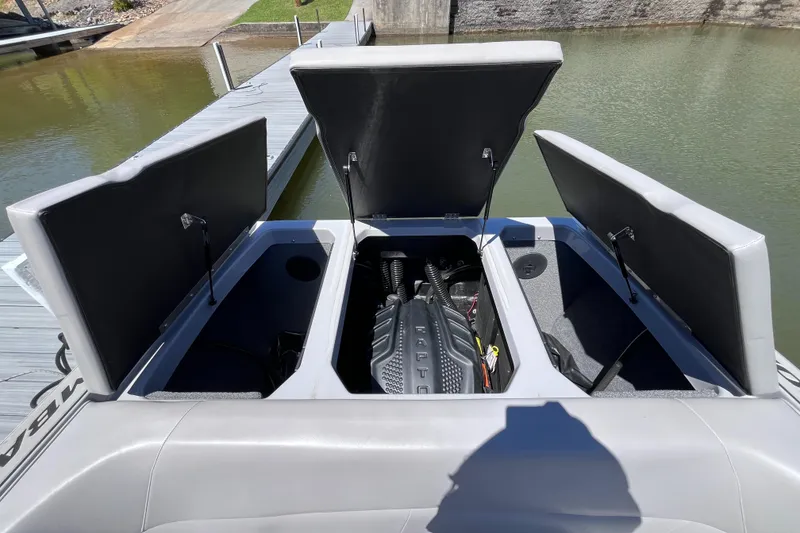 Slide: The Image of 2024 Moomba Max boat engine compartment with open hatches at a dock. - 25