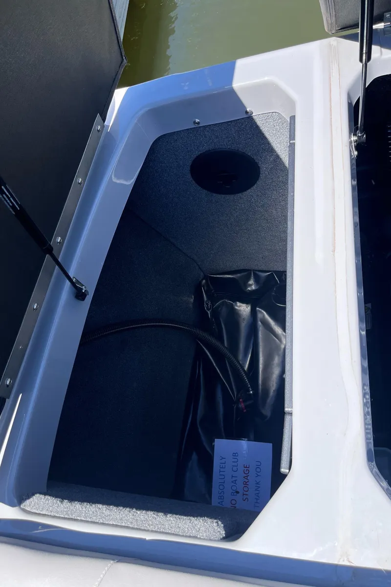 Slide: The Image of 2024 Moomba Max storage compartment with open lid, showing interior details. - 27