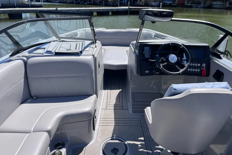 Slide: The Image of 2024 Moomba Max boat interior with sleek seating and modern dashboard on a sunny day. - 5