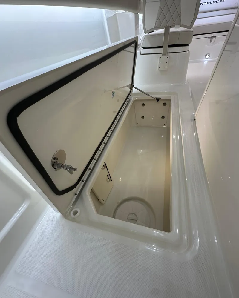 Slide: The Image of 2025 World Cat 280 CCX boat storage compartment, open lid, spacious interior. - 14