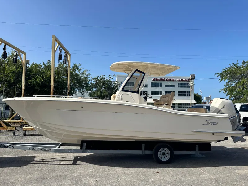 Slide: The Image of 2025 Scout 240 XSF boat on trailer in marina parking lot. - 1