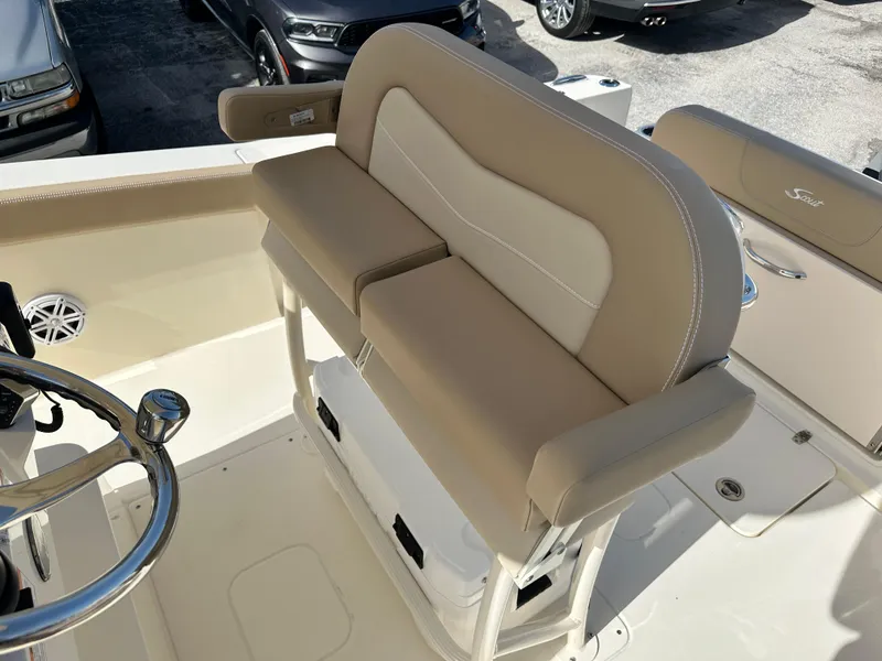 Slide: The Image of 2025 Scout 240 XSF boat seating area with beige cushions and storage underneath. - 10