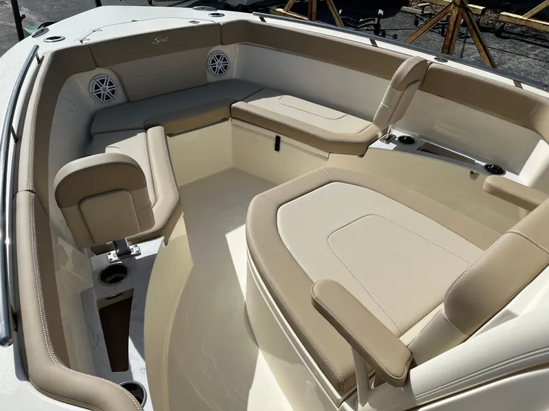 Slide: The Image of 2025 Scout 240 XSF boat interior with beige seating and cup holders. - 14