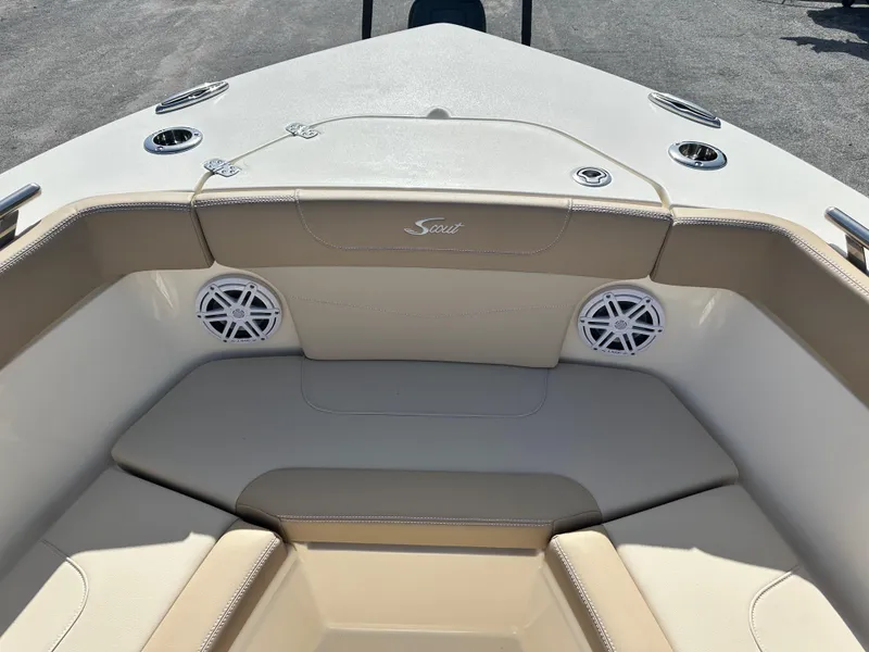 Slide: The Image of 2025 Scout 240 XSF boat interior with beige seating and built-in speakers. - 15