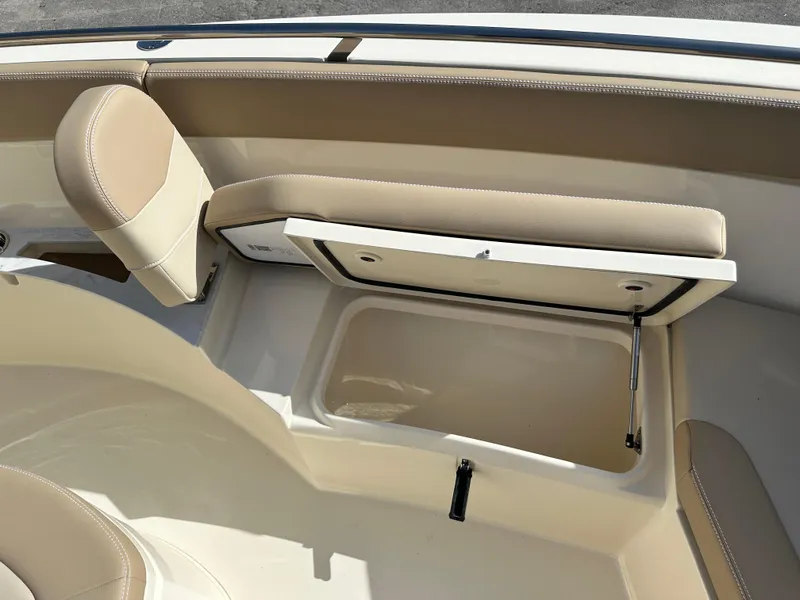 Slide: The Image of 2025 Scout 240 XSF boat with open storage compartment and beige seating. - 19