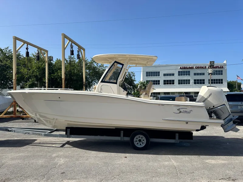 Slide: The Image of 2025 Scout 240 XSF boat on trailer in outdoor setting. - 2