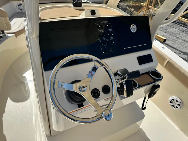 Slide: The Image of 2025 Scout 240 XSF boat helm with steering wheel and control panel. - 9