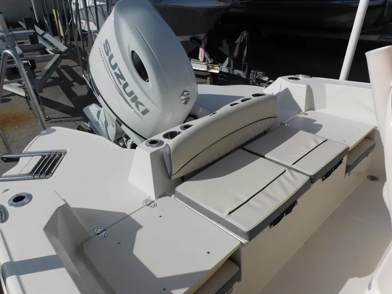 Slide: The Image of 2024 Stingray 216 CC boat with Suzuki outboard motor and cushioned seating. - 11