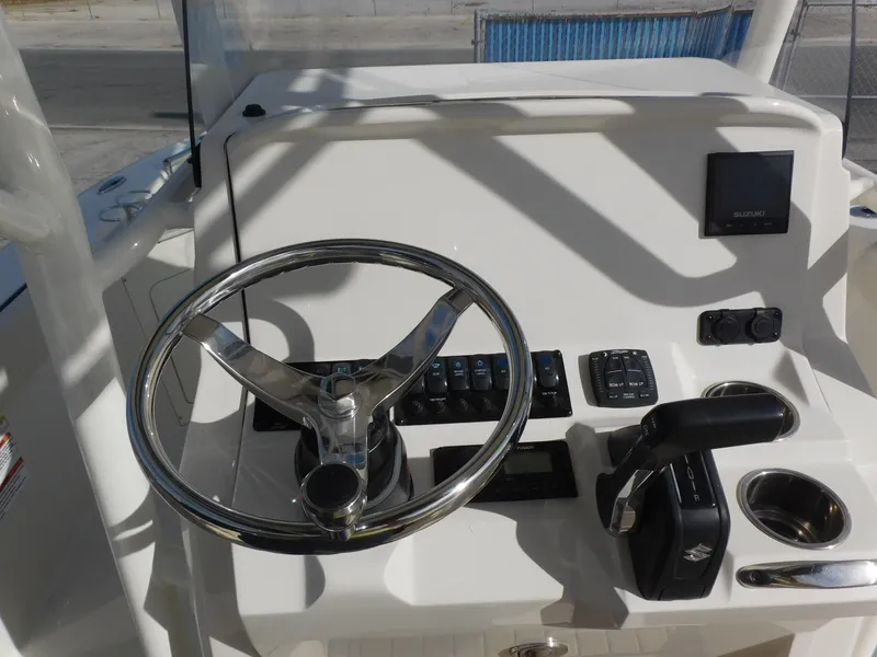 Slide: The Image of 2024 Stingray 216 CC boat helm with steering wheel and control panel. - 16