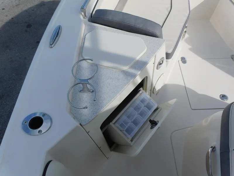 Slide: The Image of 2024 Stingray 216 CC boat interior with storage compartment and cup holders. - 24