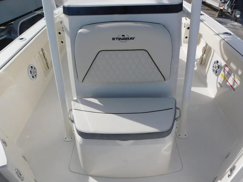 Slide: The Image of 2024 Stingray 216 CC boat interior with cushioned seating and white finish. - 26